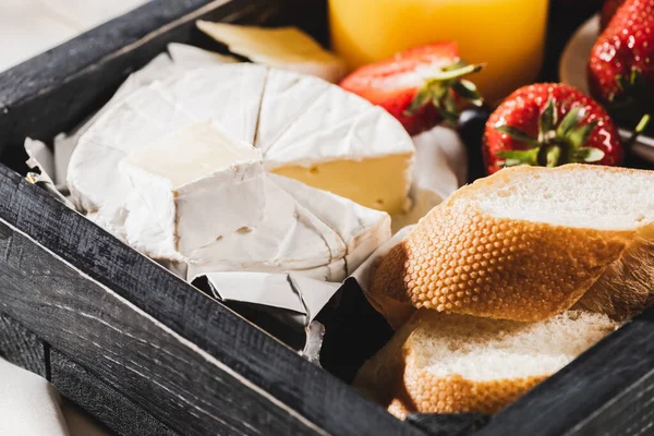 Close up view of french breakfast with Camembert, strawberries and baguette on wooden tray — Stock Photo