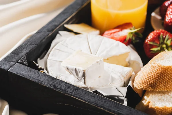 Close up view of french breakfast with Camembert, orange juice, strawberries and baguette on wooden tray — Stock Photo