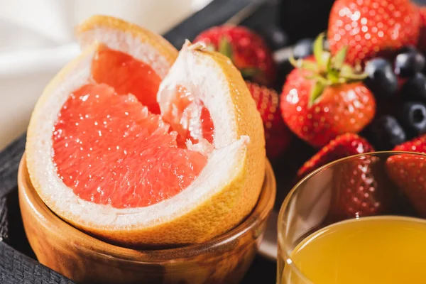 Close up view of french breakfast with grapefruit, orange juice, berries on wooden tray — Stock Photo