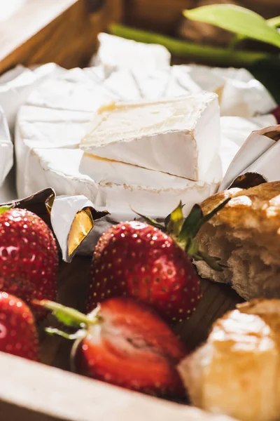 Close up view of french breakfast with croissant, Camembert, strawberries on wooden tray — Stock Photo