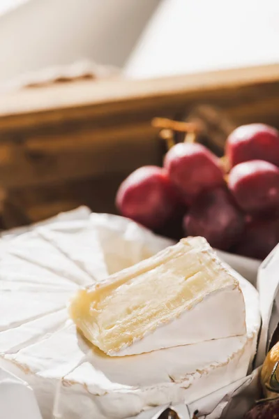 Nahaufnahme des französischen Frühstücks mit Camembert und Trauben auf Holztablett — Stockfoto
