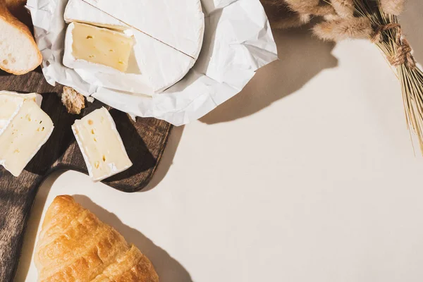 Vista superior do café da manhã francês com croissant, Camembert na placa de corte de madeira na toalha de mesa branca — Fotografia de Stock