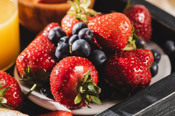 Nahaufnahme des französischen Frühstücks mit Blaubeeren und Erdbeeren auf Holztablett — Stockfoto