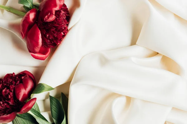 Vista dall'alto di mazzo di peonie rosse su panno bianco — Foto stock