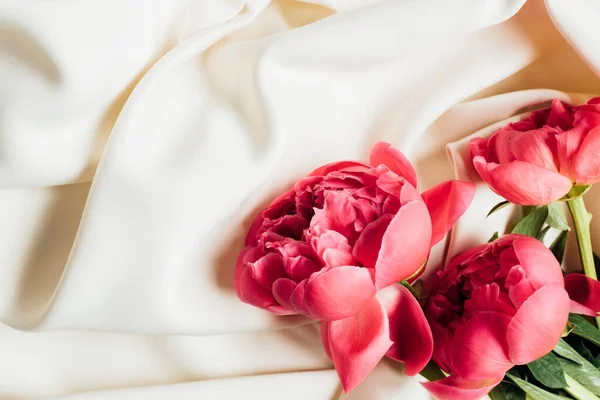 Vista dall'alto di belle peonie rosa su panno bianco — Foto stock