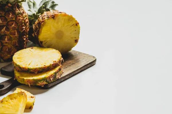 Ananas délicieux coupés frais sur planche à découper en bois sur fond blanc — Photo de stock