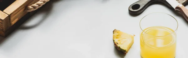 Fresh pineapple juice and cut delicious fruit on wooden tray and cutting board with knife on white background, panoramic orientation — Stock Photo