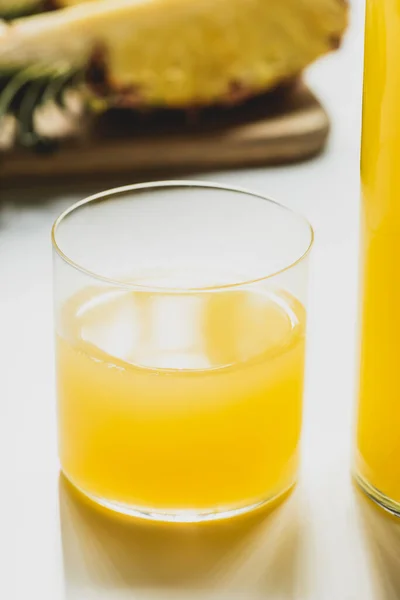 Закрыть вид свежего ананасового сока в стакане на белом фоне — стоковое фото