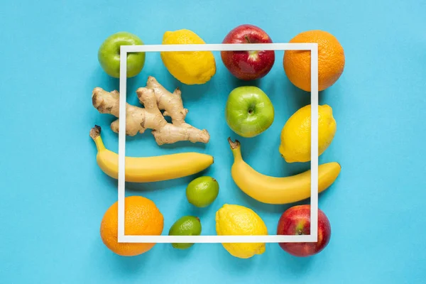 Top view of ripe whole fruits and square frame on blue background — Stock Photo