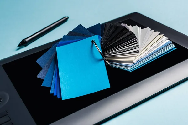 Nahaufnahme von Farbmustern auf Grafik-Tablet und Stift auf blauem Hintergrund — Stockfoto