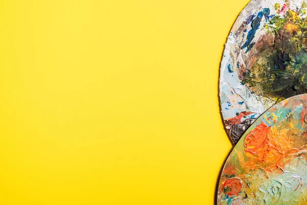 Vue de dessus des palettes dans les peintures sur la surface jaune — Photo de stock