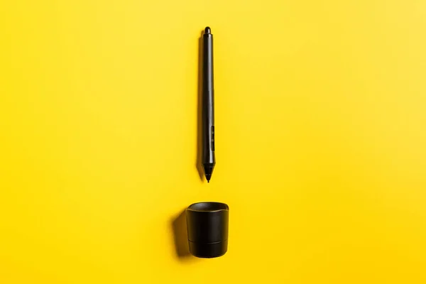 Vue du dessus du stylet de la tablette graphique et se tenir sur la surface jaune — Photo de stock