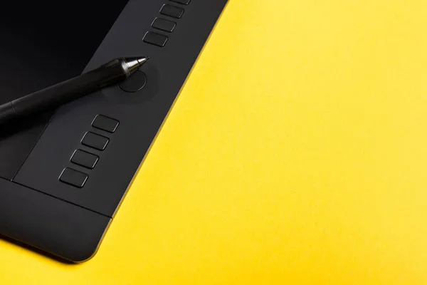 Vue rapprochée du stylet sur tablette graphique sur fond jaune — Photo de stock