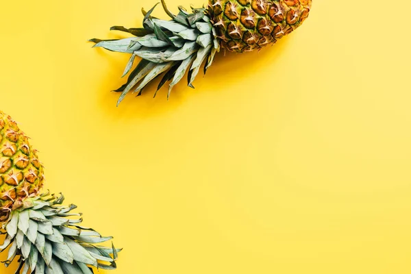 Vue de dessus des ananas frais mûrs sur fond jaune — Photo de stock