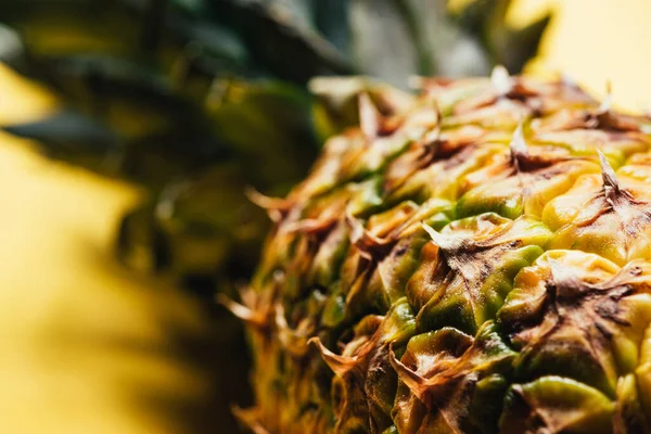 Nahaufnahme der strukturierten Schale der Ananas auf gelbem Hintergrund — Stockfoto