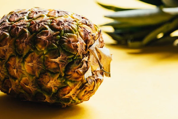 Nahaufnahme der strukturierten Schale der Ananas auf gelbem Hintergrund — Stockfoto