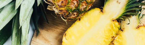 Vista dall'alto di succose metà ananas su tagliere in legno, colpo panoramico — Foto stock