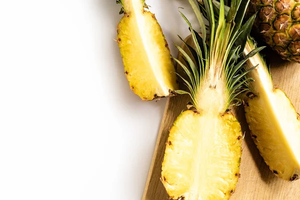 Draufsicht auf geschnittene saftige Ananas auf Schneidebrett auf weißem Hintergrund — Stockfoto