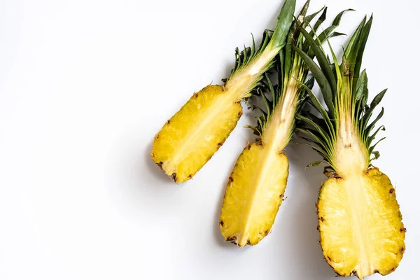 Draufsicht der geschnittenen reifen Ananas mit grünen Blättern auf weißem Hintergrund — Stockfoto