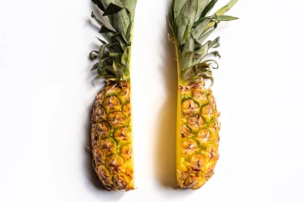 Top view of cut ripe pineapple with green leaves on white background — Stock Photo