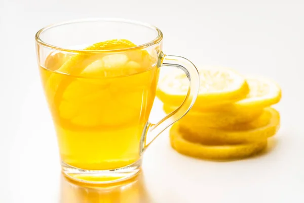 Вибірковий фокус гарячого чаю в склянці біля скибочок лимона на білому фоні — стокове фото