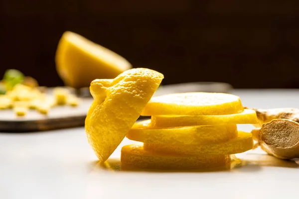 Selective focus of sliced lemon and ginger root on white and black background — Stock Photo