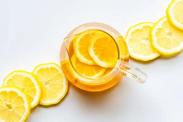 Draufsicht auf heißen Tee mit Zitronenscheiben auf weißem Hintergrund — Stockfoto