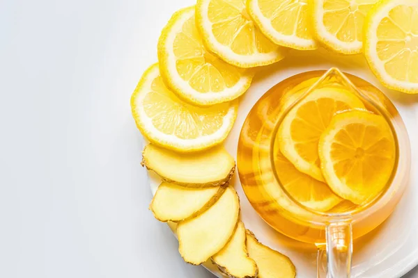 Вид на горячий чай в стеклянном чайнике с ломтиками лимона на белом фоне — Stock Photo
