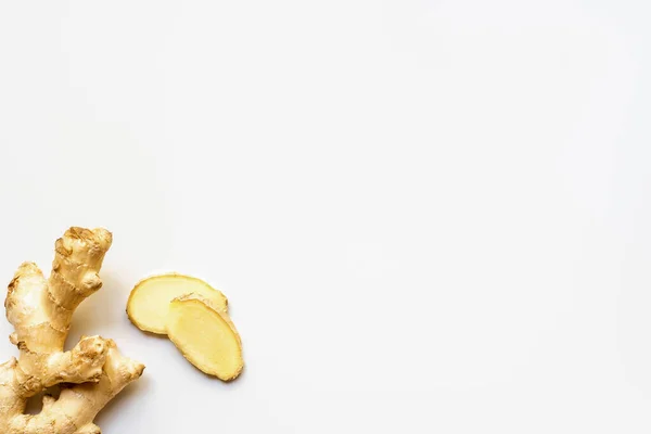 Top view of whole ginger root and slices on white background — Stock Photo