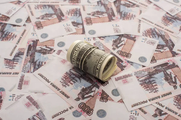 Dollars rouleau de trésorerie sur les billets de banque en rouble russe — Photo de stock