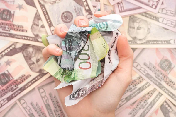 Cropped view of woman holding crumpled ruble banknotes near dollars — Stock Photo