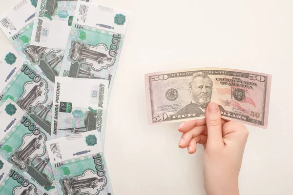 QUIIV, UCRÂNIA - MARÇO 25, 2020: visão cortada de uma mulher segurando uma nota de dólar perto de rublos russos isolados em branco — Fotografia de Stock