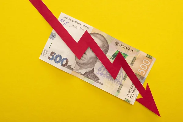 KYIV, UKRAINE - MARCH 25, 2020: top view of crisis graph on ukrainian hryvnia banknote isolated on yellow — Stock Photo