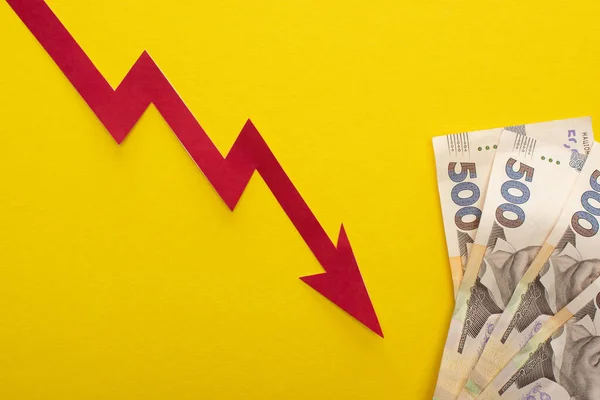 Top view of crisis graph near ukrainian hryvnia banknotes isolated on yellow — Stock Photo