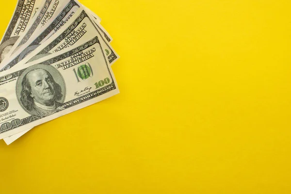 QUIIV, UCRÂNIA - MARÇO 25, 2020: visão superior de dólares isolados em amarelo com espaço de cópia — Fotografia de Stock