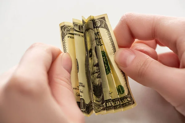 Enfoque selectivo de la mujer que sostiene el billete de dólar arrugado en manos aisladas en blanco - foto de stock