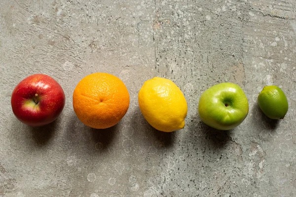 Vista superior de sabrosas frutas de colores en la superficie de hormigón gris - foto de stock