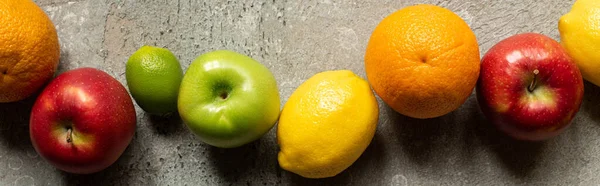 Vista superior de frutas coloridas saborosas na superfície de concreto cinza, tiro panorâmico — Fotografia de Stock