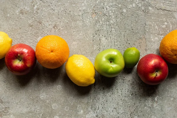Вид зверху смачні барвисті фрукти на сірій бетонній поверхні — стокове фото