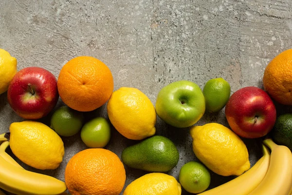 Vista superior de sabrosas frutas de colores en la superficie de hormigón gris - foto de stock