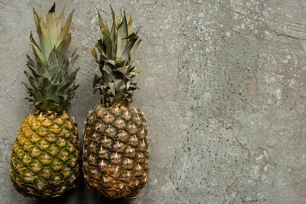 Vue de dessus des ananas mûrs sur la surface en béton gris avec espace de copie — Photo de stock