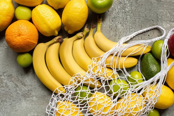 Vista superior de frutas deliciosas coloridas e saco de cordas na superfície de concreto cinza — Fotografia de Stock