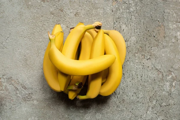 Vista superior de bananas deliciosas coloridas na superfície de concreto cinza — Fotografia de Stock