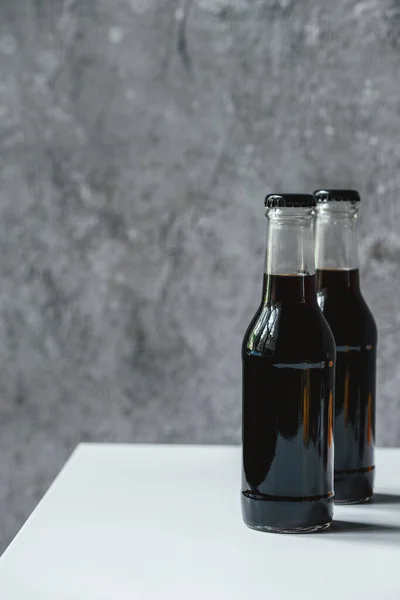 Café infusé froid en bouteilles sur table blanche — Photo de stock