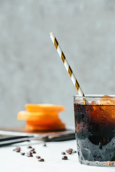 Messa a fuoco selettiva di caffè freddo birra con ghiaccio e paglia da bere sul tavolo bianco — Foto stock