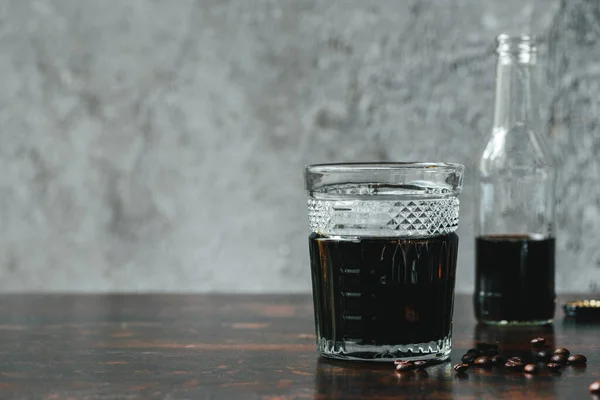 Selektiver Fokus von kaltem Brühkaffee in Flasche und Glas in der Nähe von Kaffeebohnen — Stockfoto