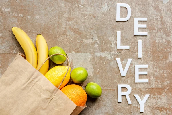 Top view of word delivery near paper bag with fresh fruits on weathered surface — Stock Photo