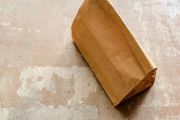 Bolsa de papel marrón sobre superficie erosionada - foto de stock