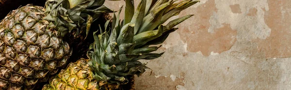 Top view of ripe exotic pineapples on weathered surface, panoramic crop — Stock Photo
