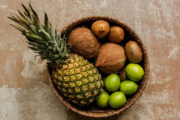 Top view of ripe exotic fruits in wicker basket on weathered surface — Stock Photo